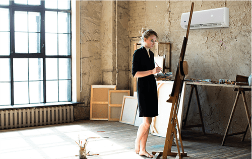 Vrouw die schildert met airco op achtergrond